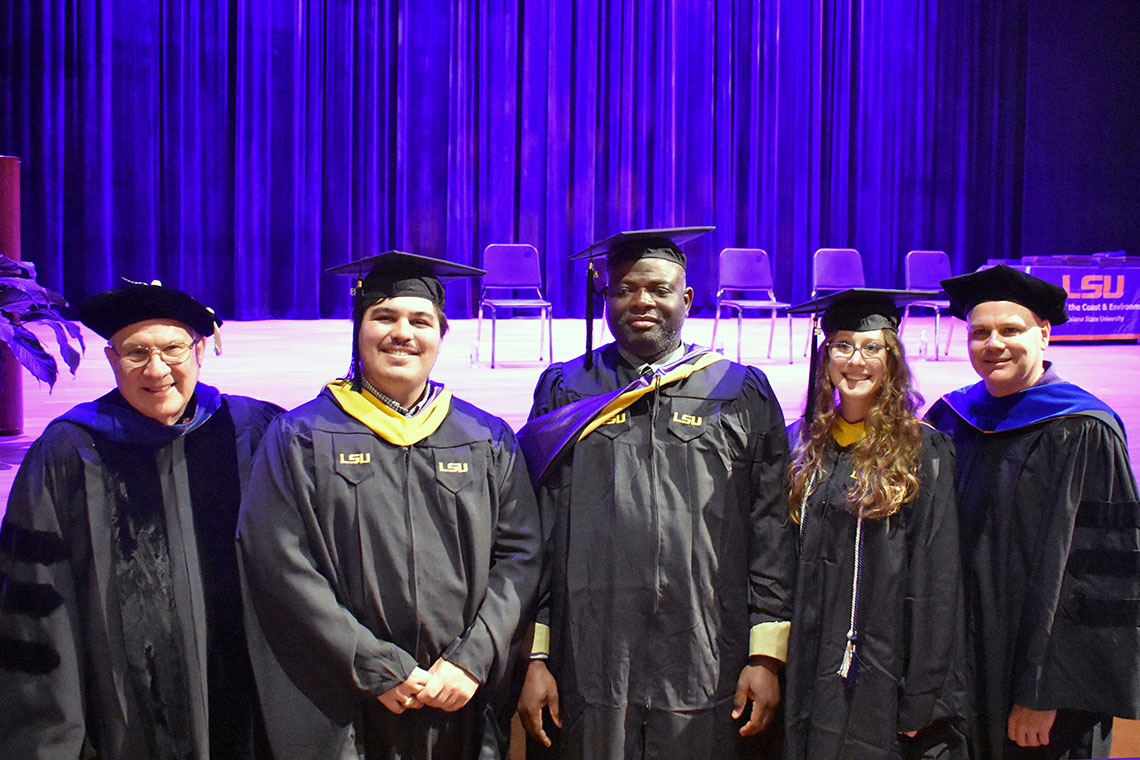 a group of environmental sciences graduates stand with their faculty members