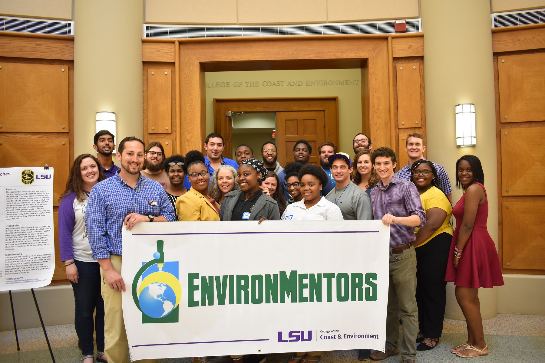 group photo of EnvironMentors hold a banner with the EnvironMentors logo on it