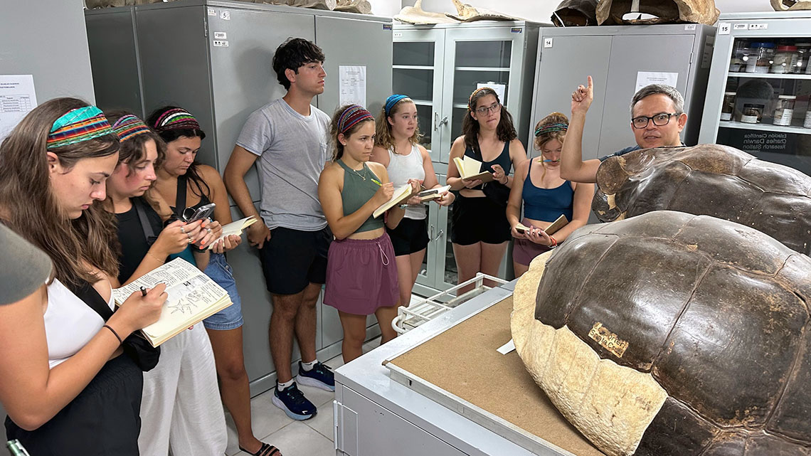Coastal Environmental Science students take notes as an instructor points to a tortoise shell