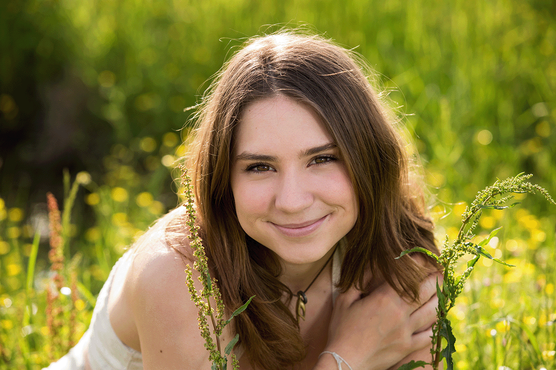 A woman in green grass smiles