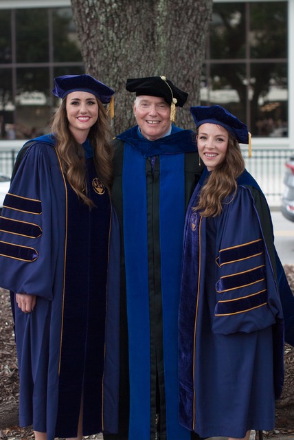 A man and two women in graduation robes