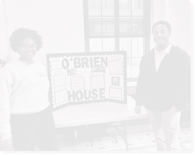 A bulletin board displays information about O'Brien House with sections on SMART goals, federal and local policies, services offered, populations served, and interventions utilized. Description generated by AI