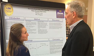 Photo of one of the distinguised scholars presenting her research to Dr. Neil Mathews