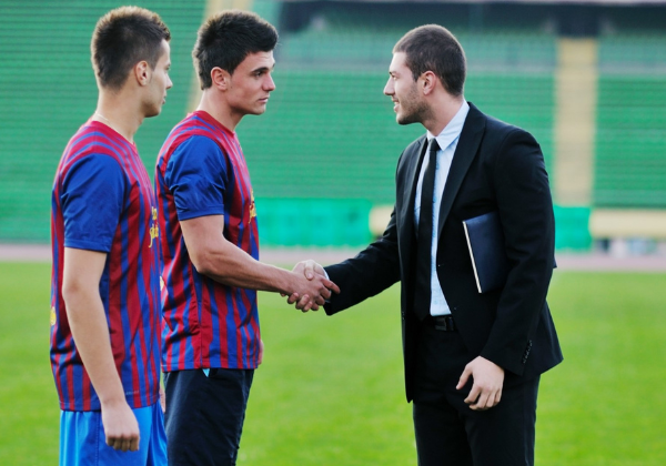 soccer players and businessman shaking hands