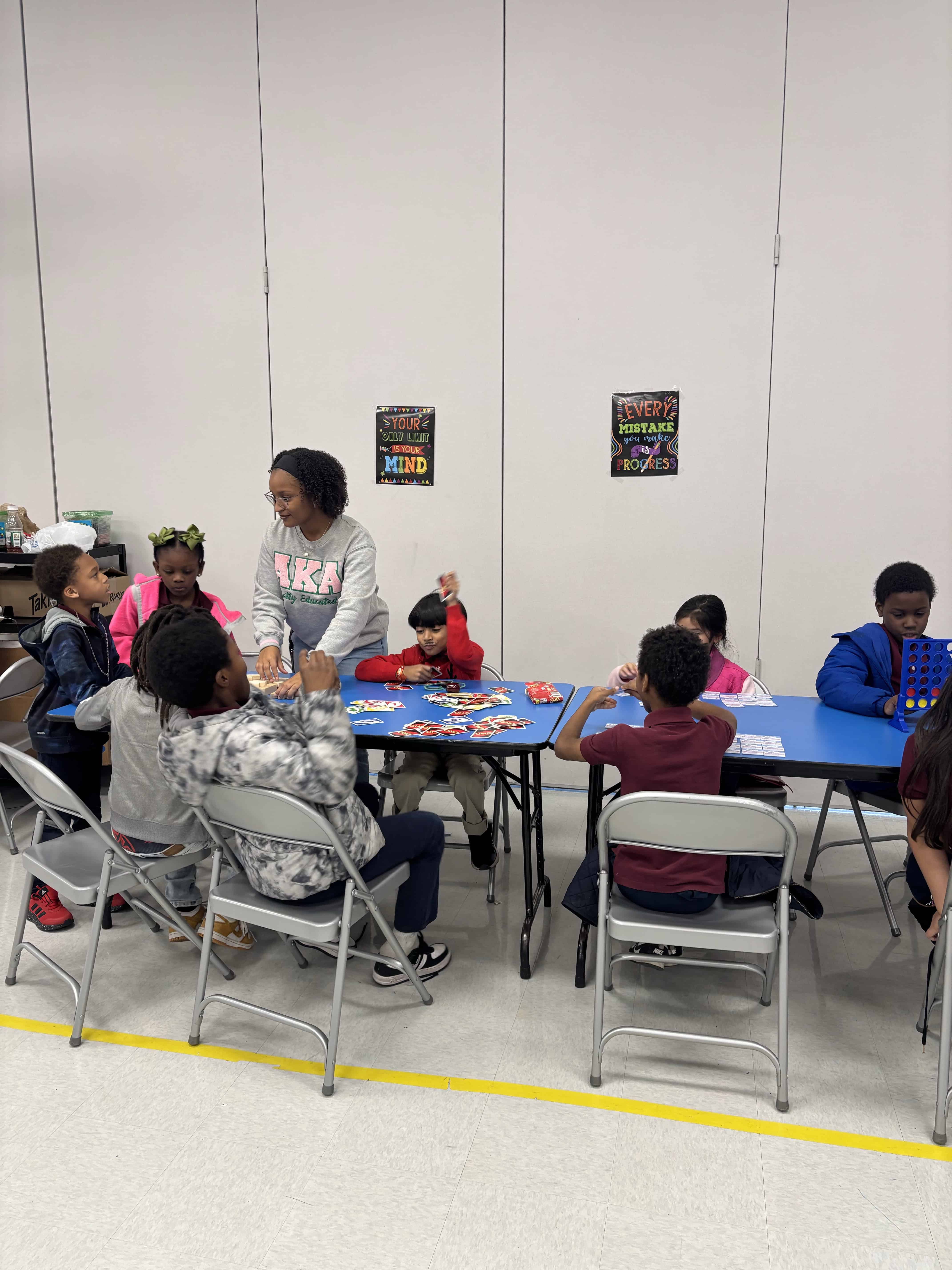 Paris Bickham playing a card game with elementary students sitting at a table