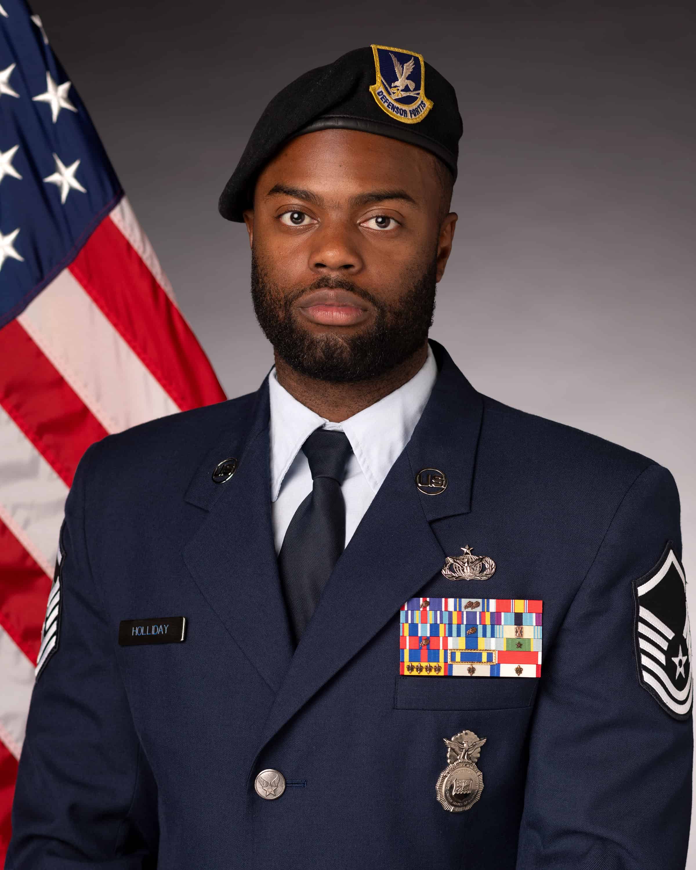Andrae Holliday in Air Force uniform in front of the American flag