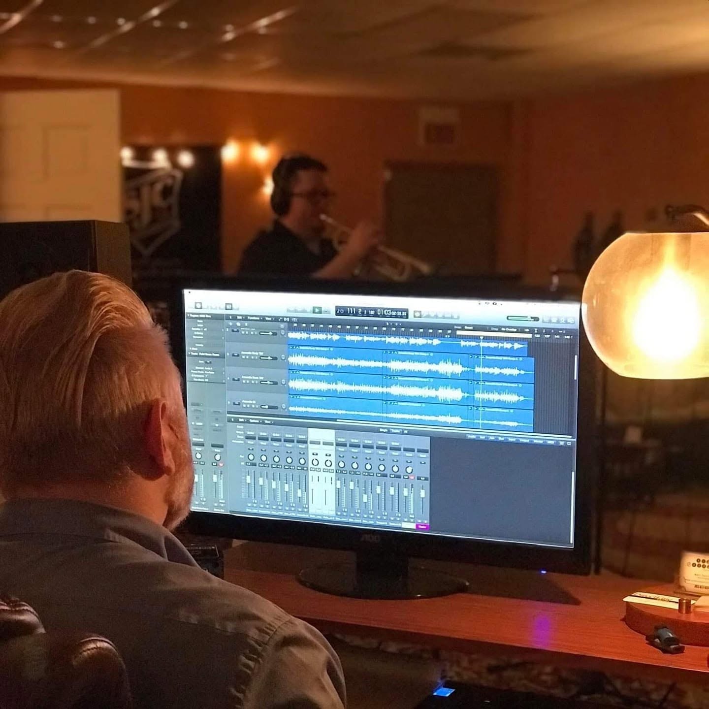 Josh Meade recording his trumpet playing in a studio