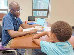 Tutor works one-on-one with a young student during a reading activity.