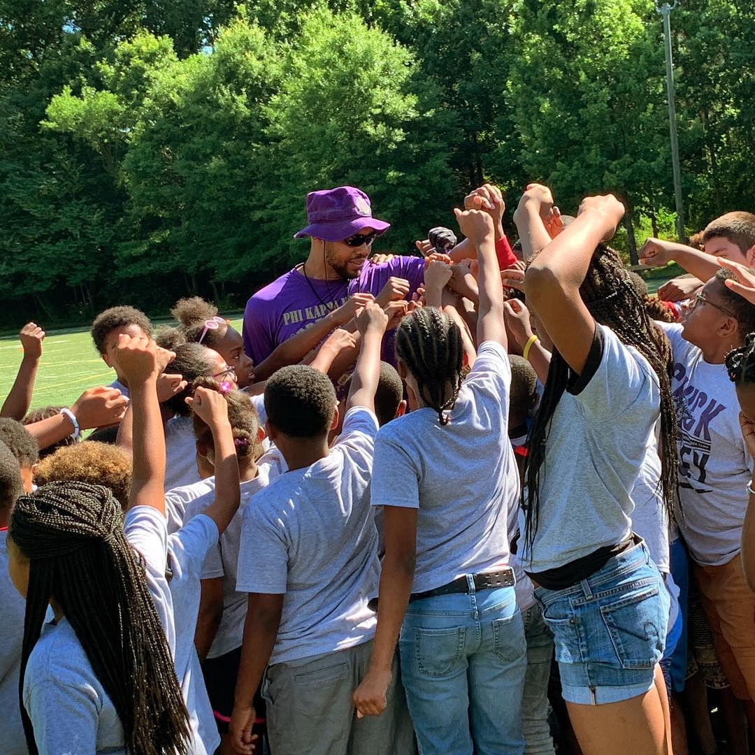 Chuck Wiley with a group of children in a huddle