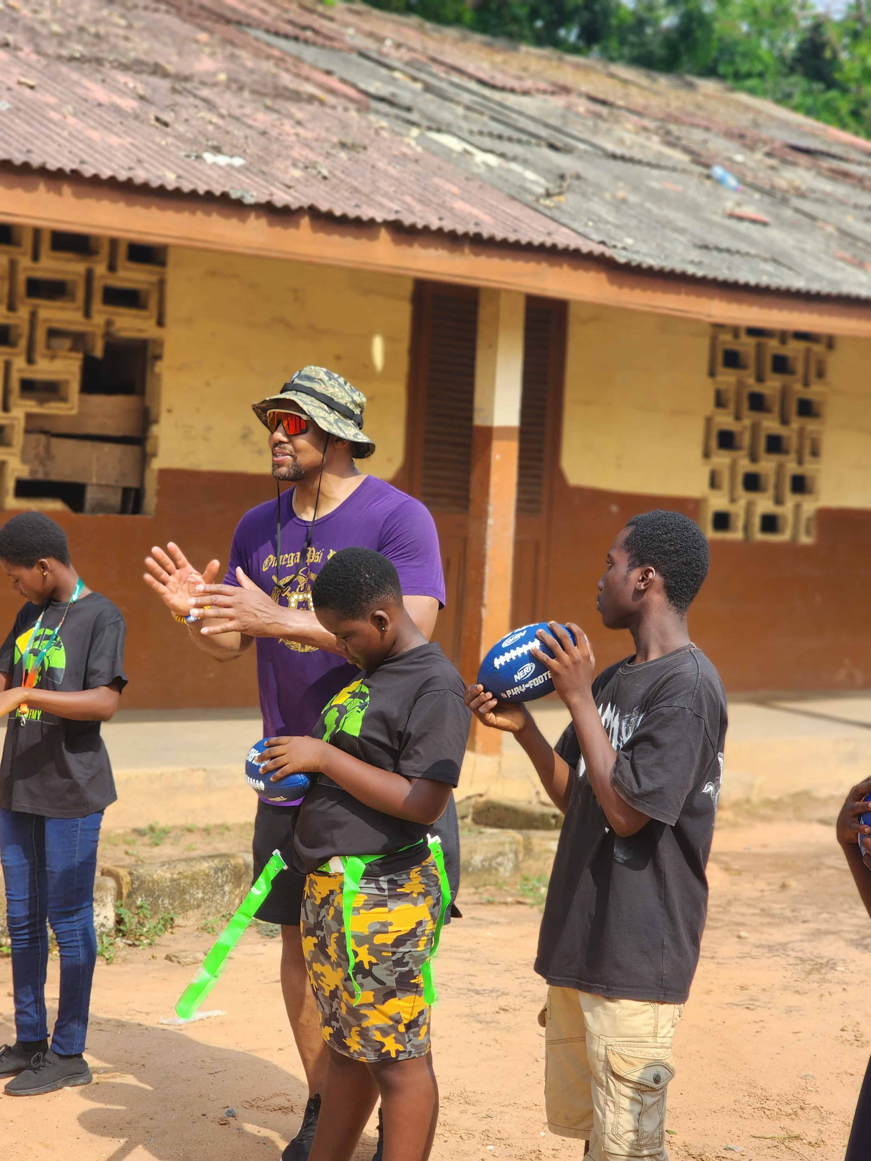 Chuck Wiley playing football with students in Africa