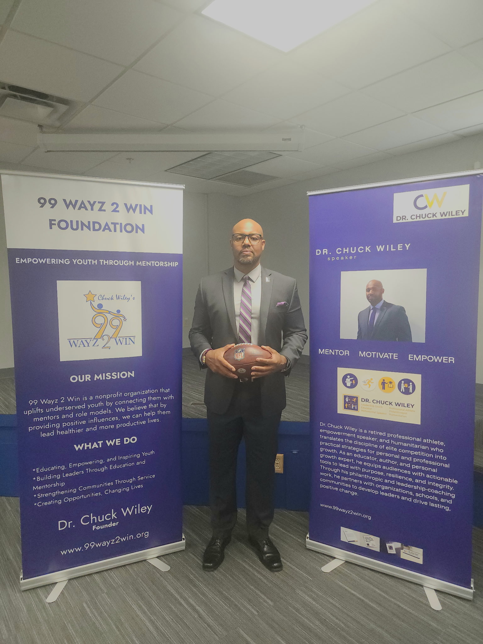 Chuck Wiley with signage for his 99 Wayz 2 Win Foundation