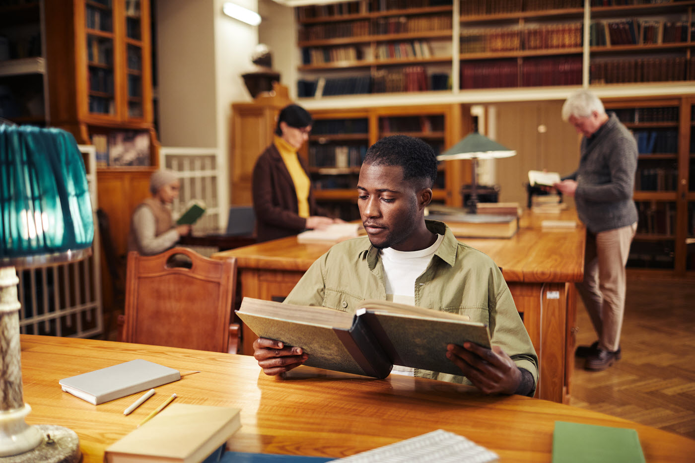 image of young black man reading in library