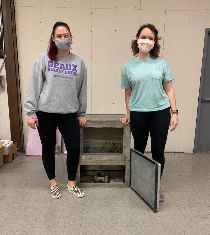 Two women wearing masks standing next to eachother