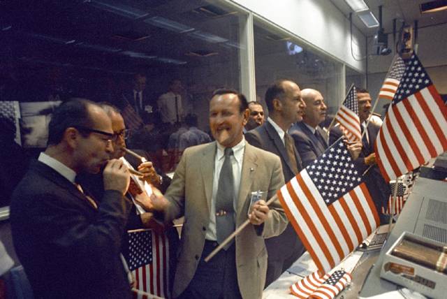 Max Faget celebrating with coworkers and American flags.
