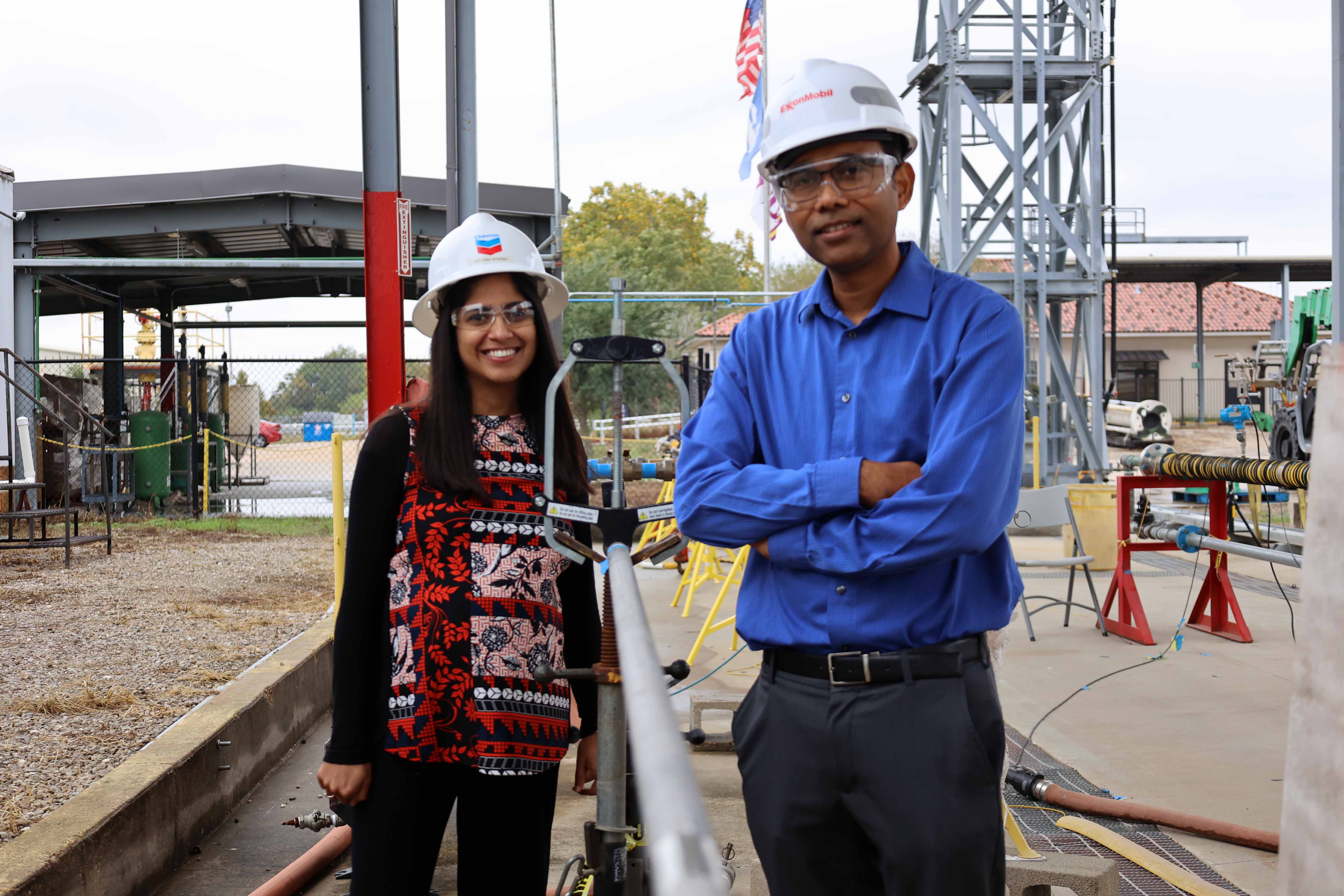 LSU Engineering faculty wearing hard hats in front of oil and gas facility.