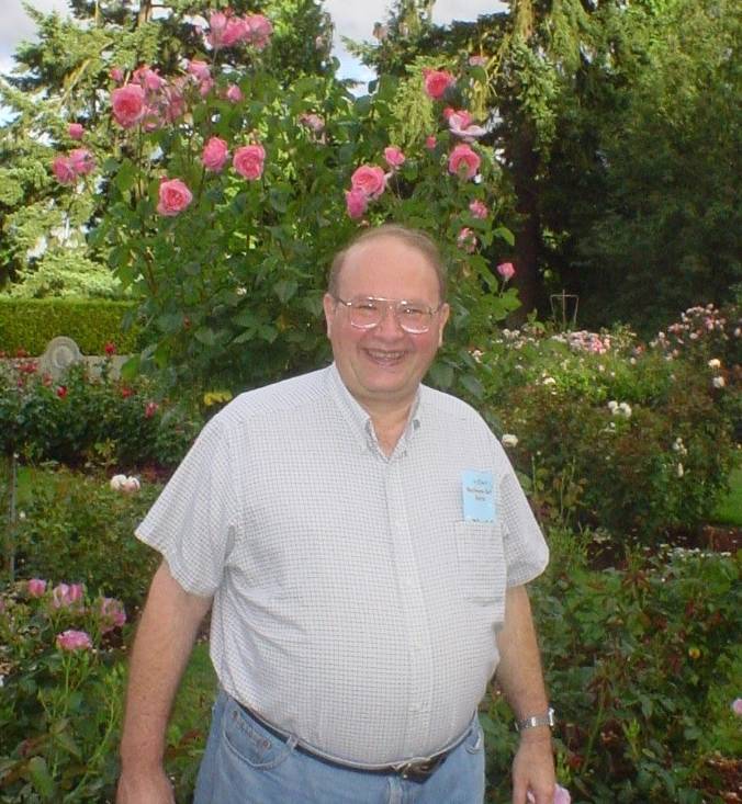 Dr. Mailander standing in front of rose bush