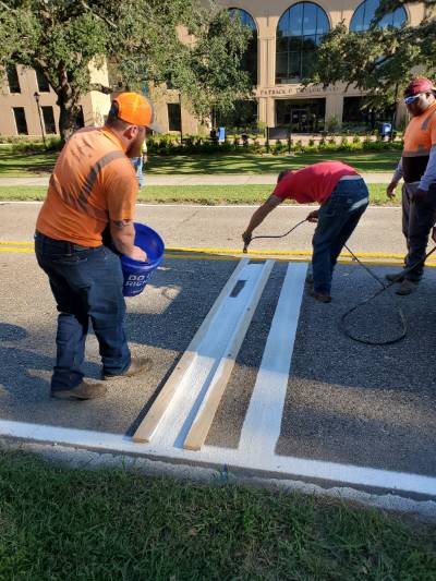 Men painting striped on road