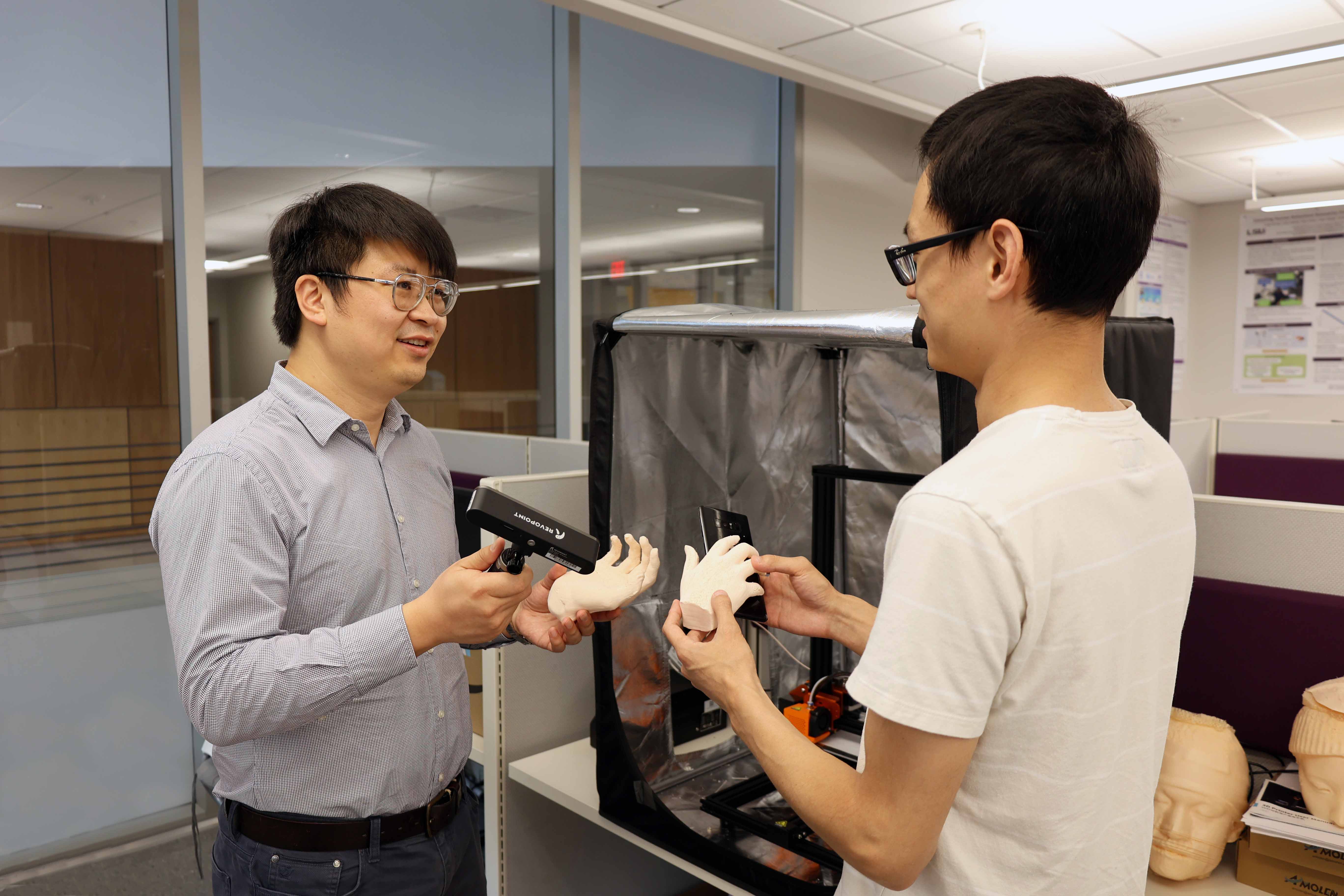 Image of Dr. Chen Wang with student in lab.
