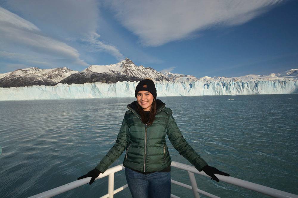 Ana Alvarado on the front of a boat with glacier in the background