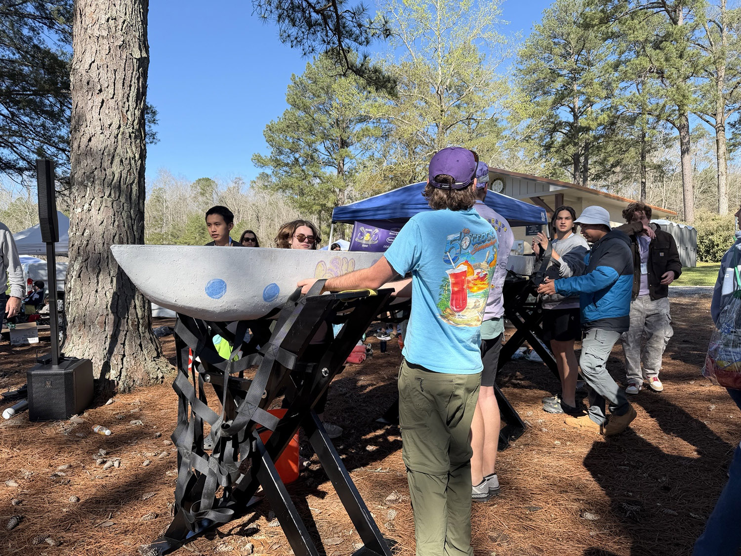 Concrete canoe team lifting boat