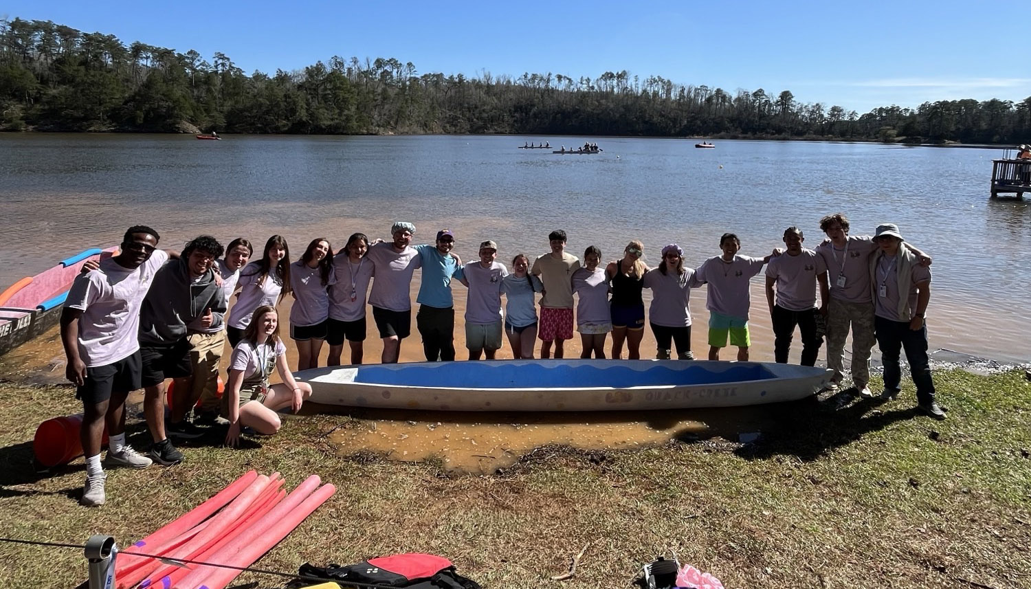 Concrete canoe team around their boat