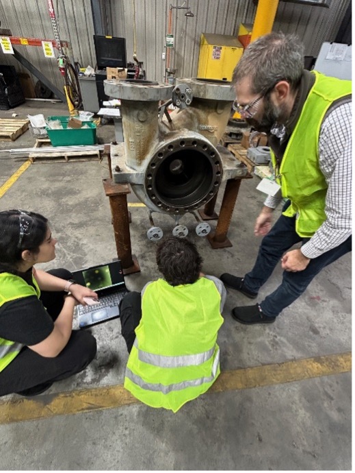 Gilbert and student inspecting equipment