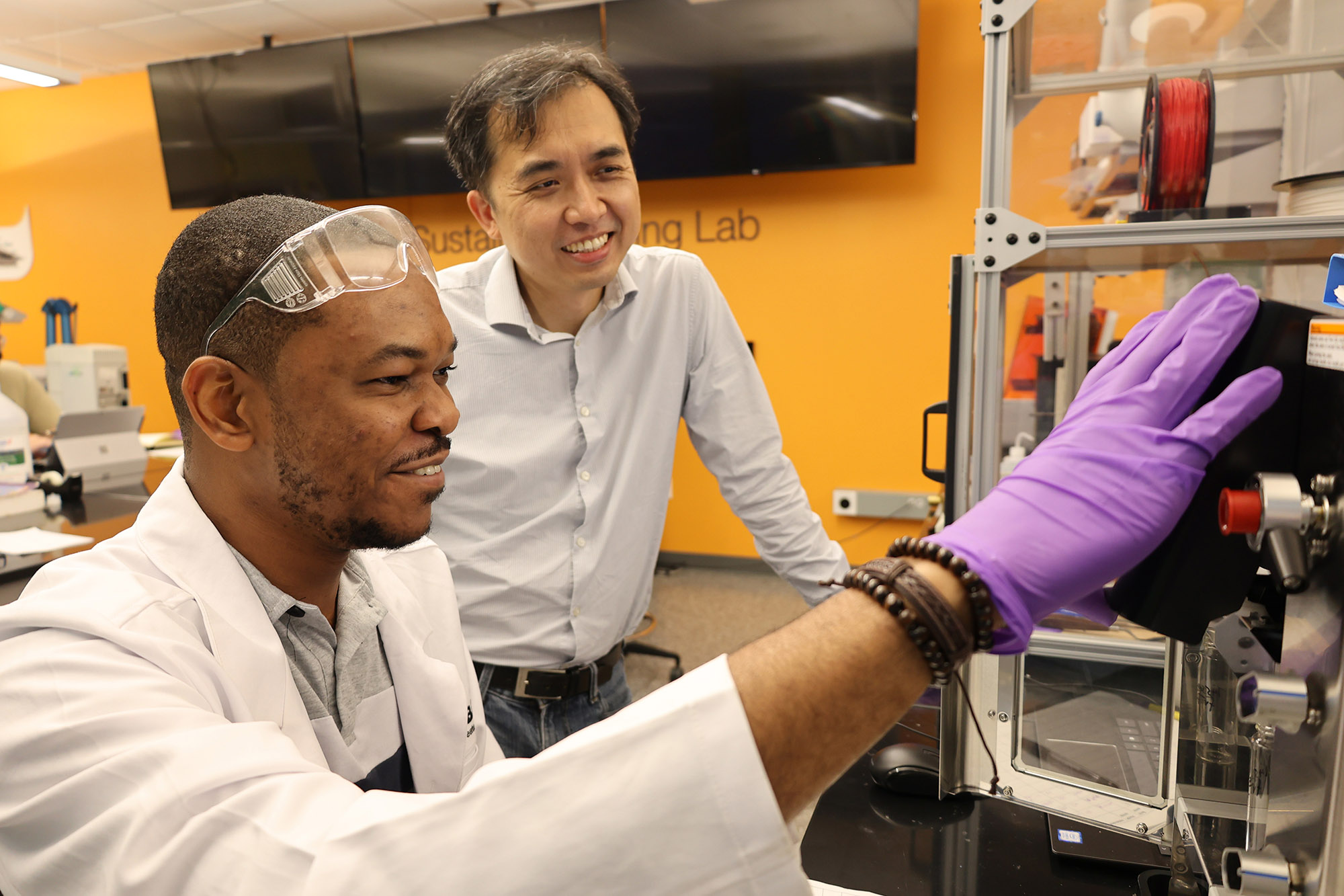 Jimmy Lawrence and student working with lab equipment