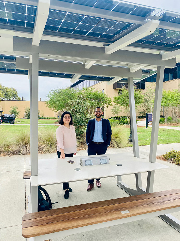 Professors standing under solar shade