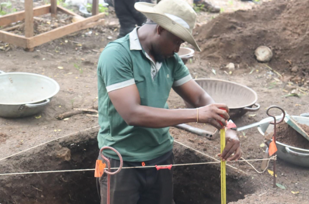 Doctoral student Kelvin Asare recording a stratigraphic profile during the excavation of a test unit at Nsakye.