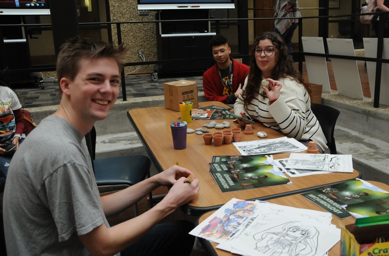 Students relaxing with coloring pages, books, rocks, and pots. Photo Credit: Alaina Davanzo.
