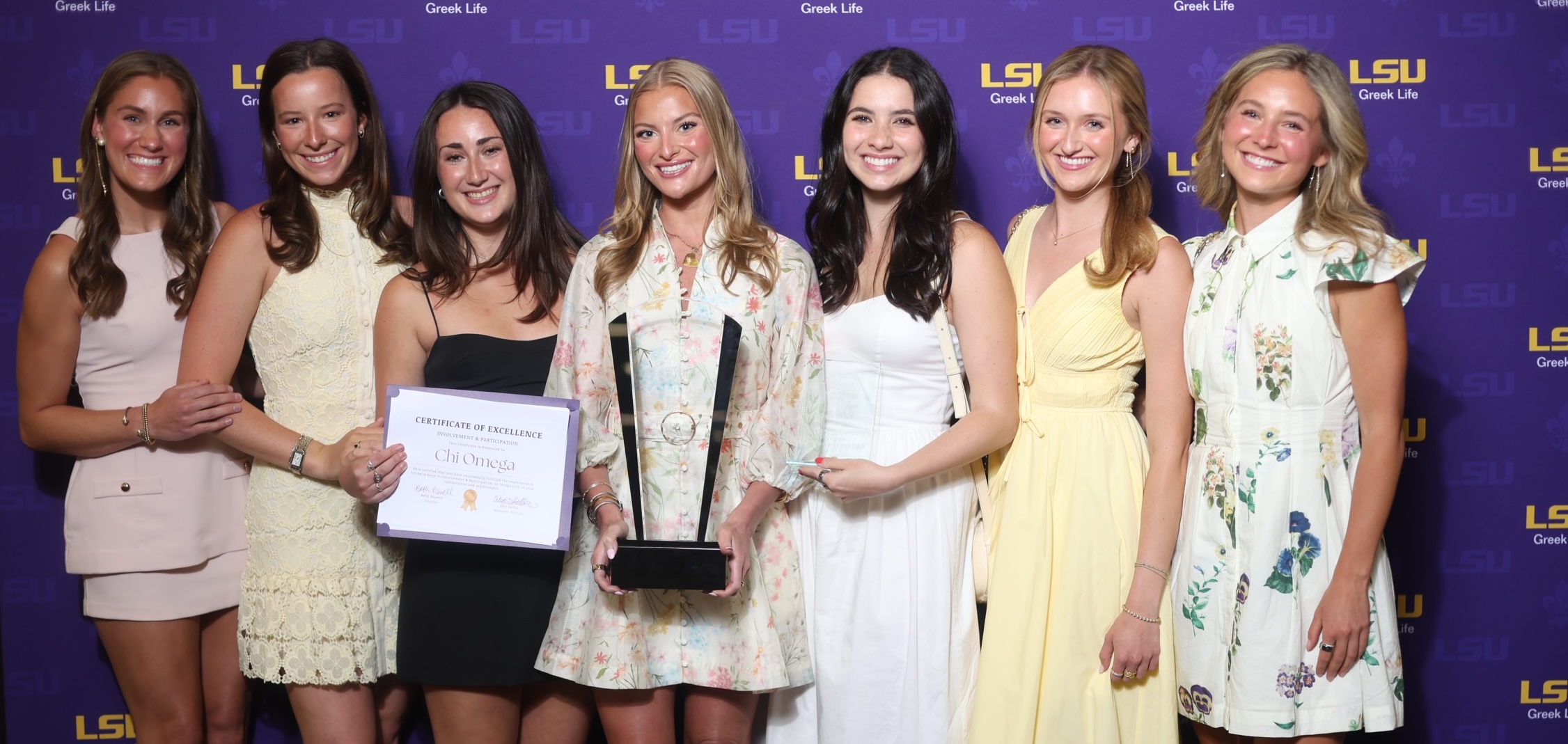 chi omega members pose with award