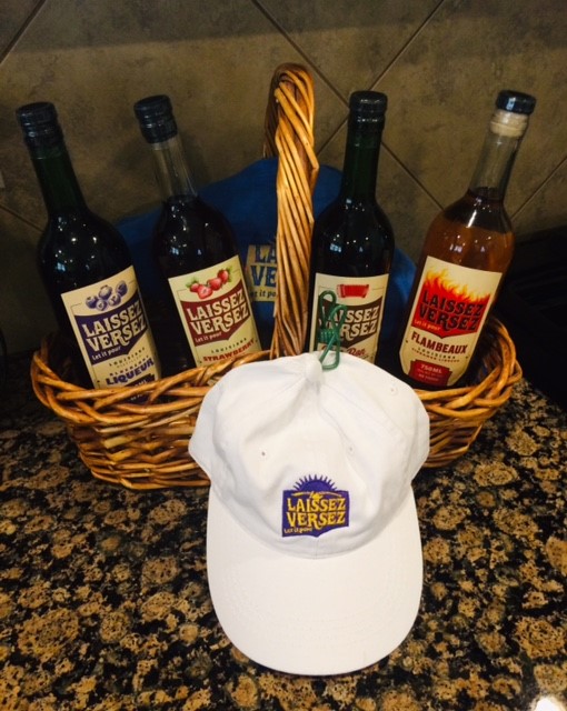 4 bottles of liqueur, a t-shirt and hat in a wicker basket