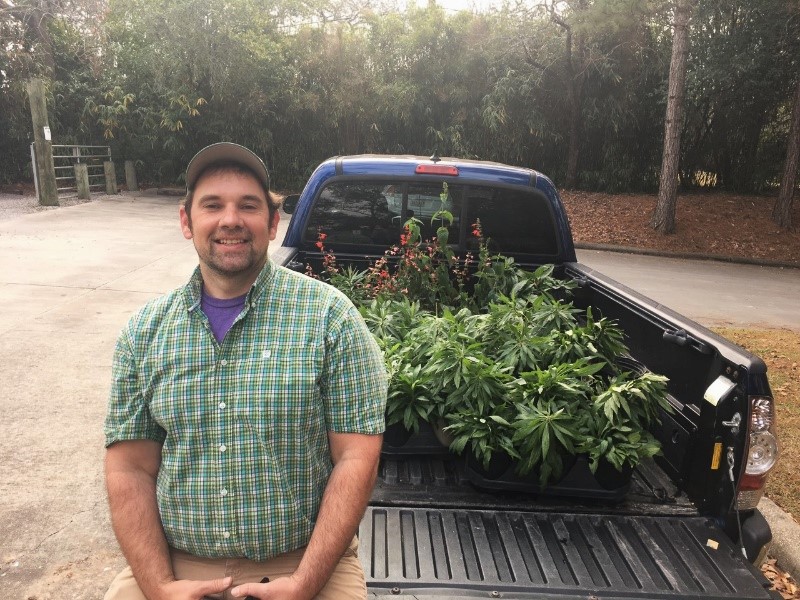 Graduate intern, Dan Cooke, by his truck bed filled with native plants