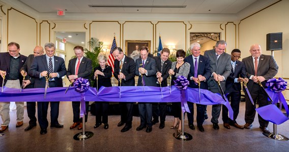Ogden Honors College stakhodlers cutting a large purple ribbon