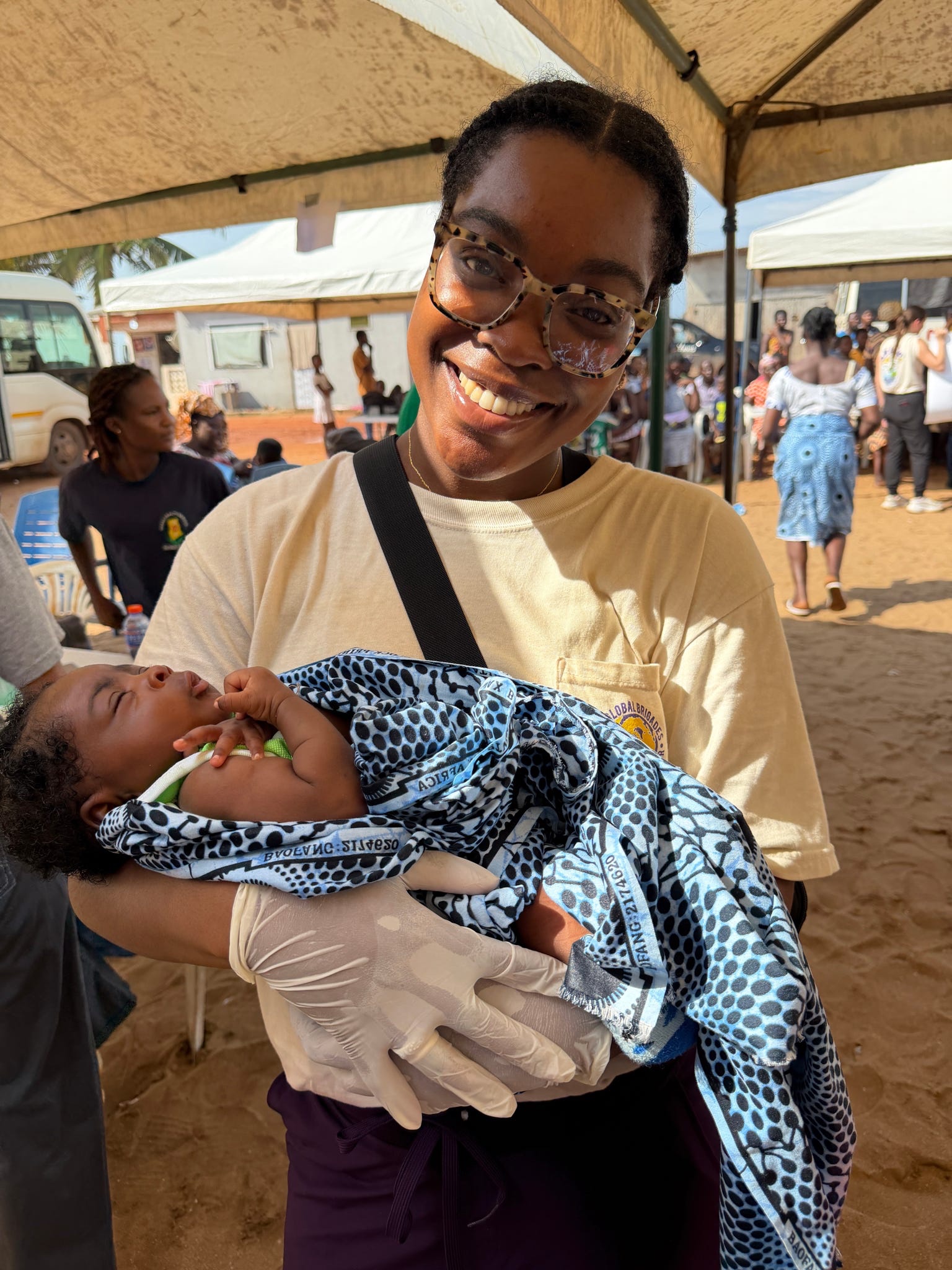 Blessing Nwina in Ghana holding a baby.