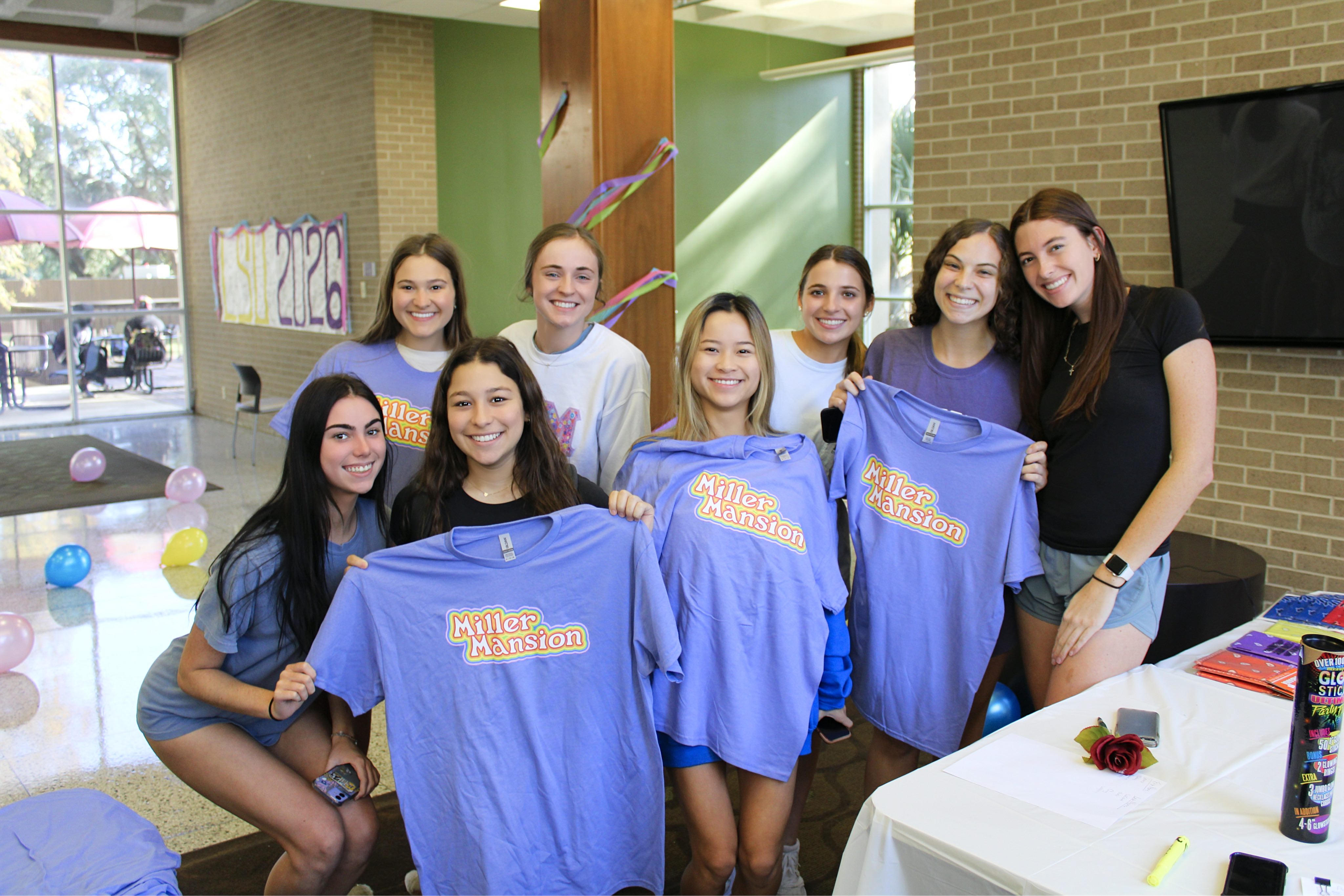 Miller Hall residents posing with new shirts that say Miller Mansion.