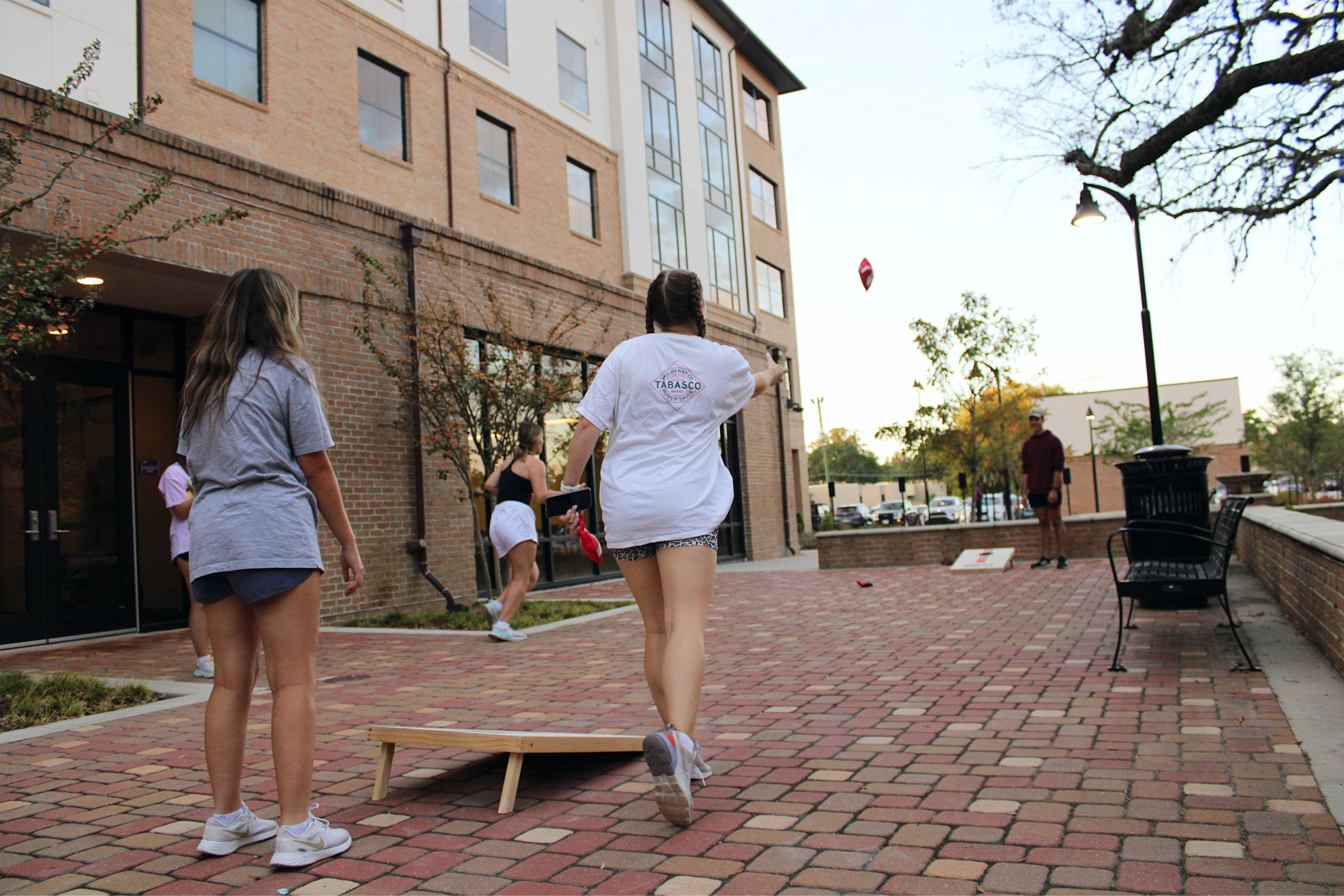 Students playing cornhole outside of Cedar Hall.