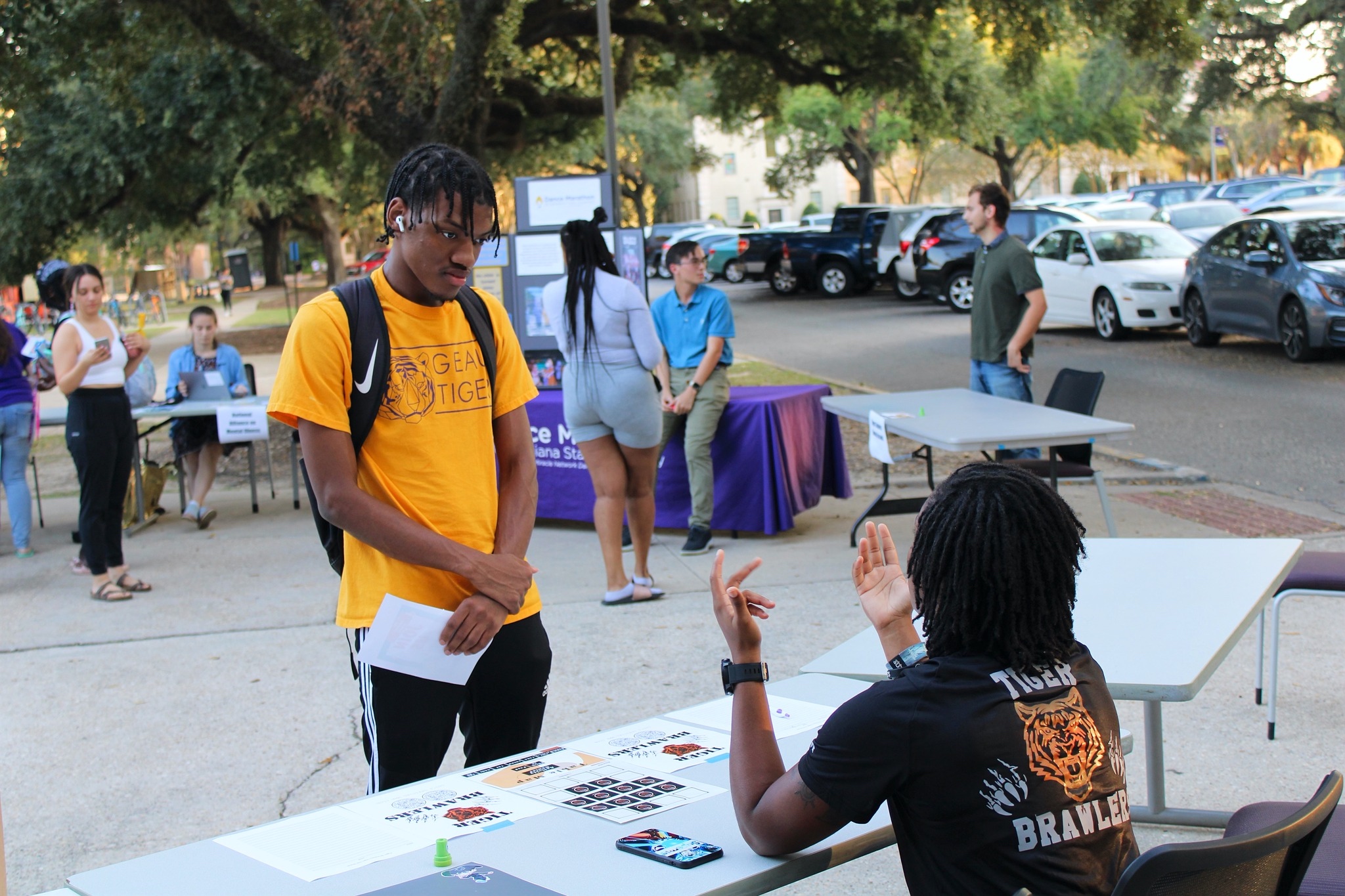 Student talking to a member of the Tiger Brawlers at an East Campus Apartments event.