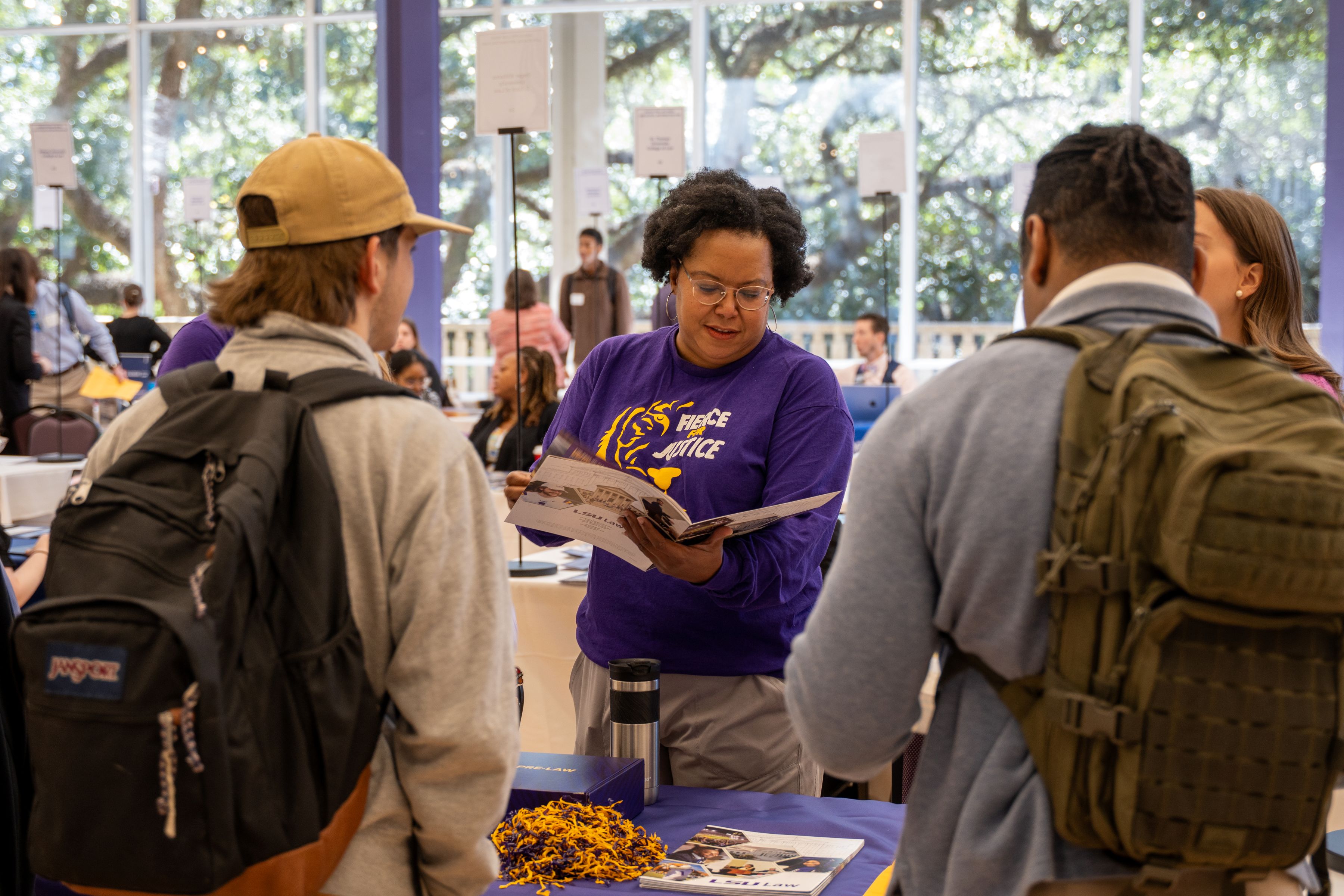 LSU Law representative talking to two students at an information fair