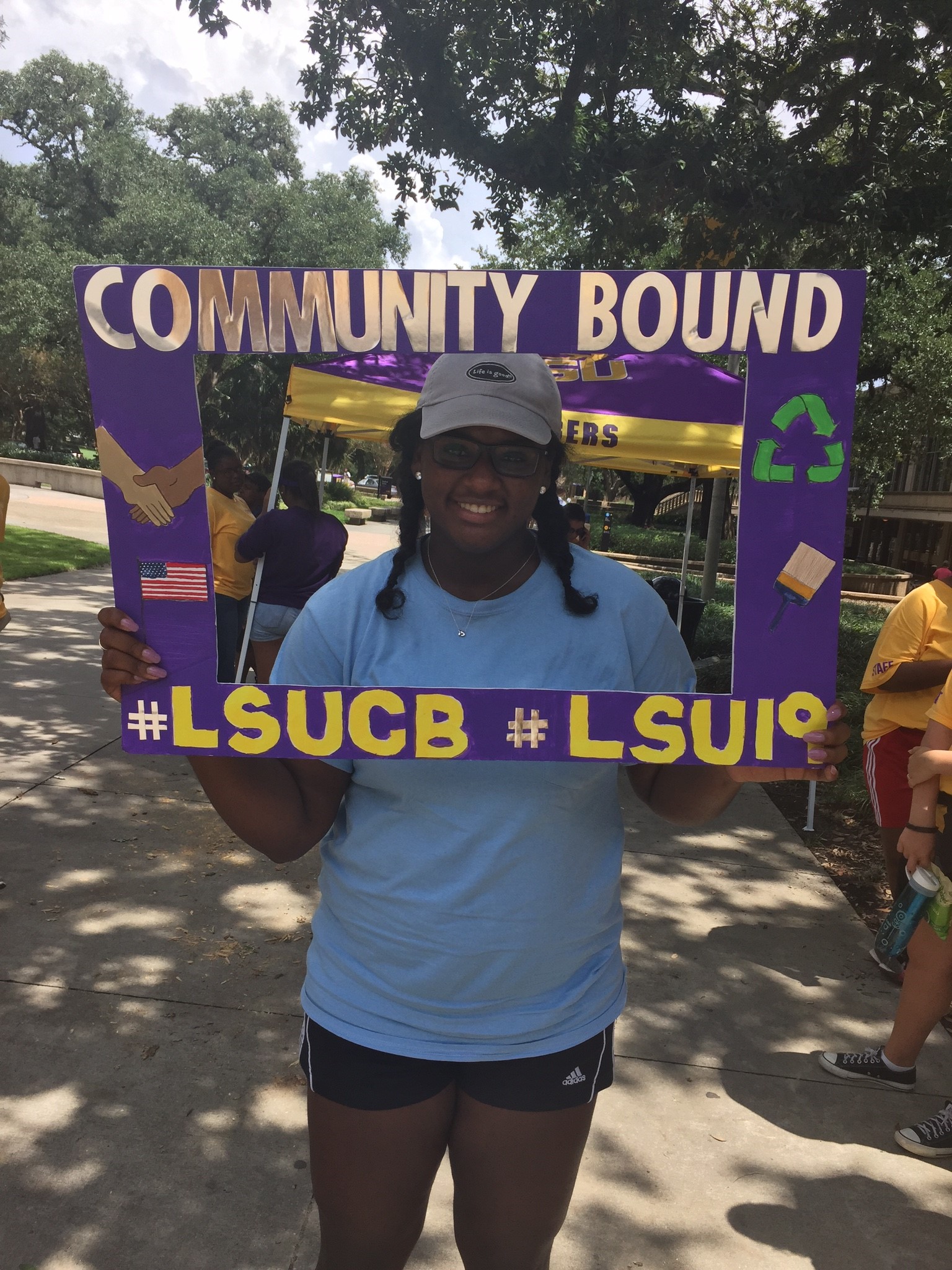 Layah attends LSU community engagement event, poses with purple border.