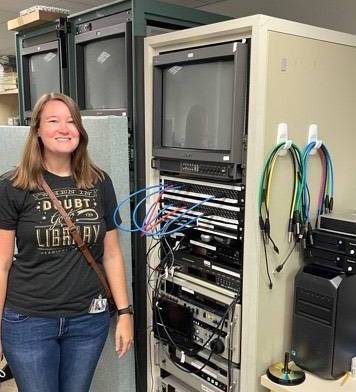 Mackenzie Roberts Beasley stands next to equipment she uses to digitize video formats.