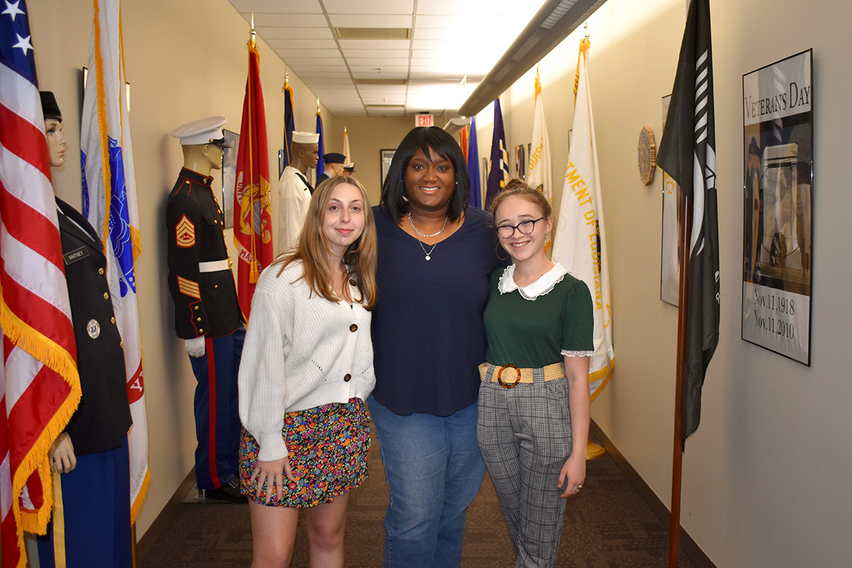 Tara Jones poses with two students