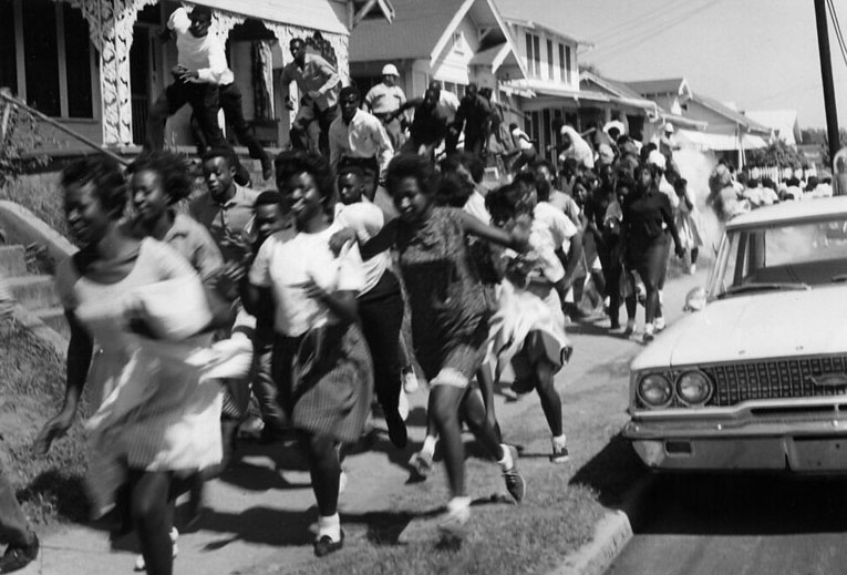 Police chase Black teenagers alongside a Shreveport street in 1963