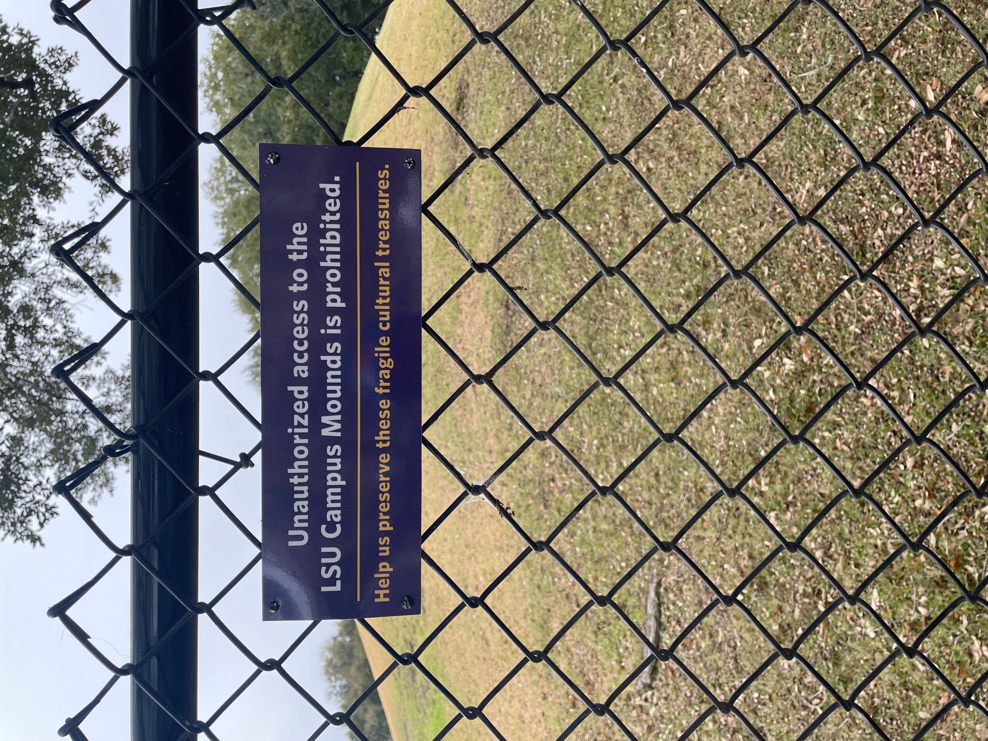 sign on fence at LSU Campus Mounds warns against unauthorized access