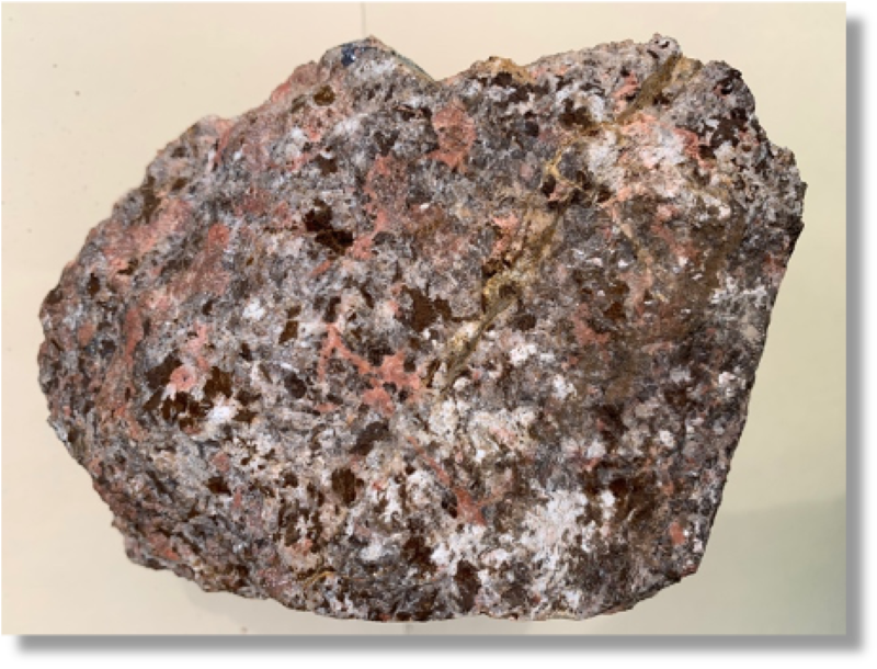 A piece of carbonatite from Mountain Pass, CA containing rare earth elements. The fleshy colored minerals are bastnäsite. 