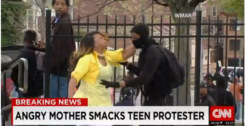 An image of a mother trying to stop her son from joining the violent activities during the Baltimore riot on April 27, 2015