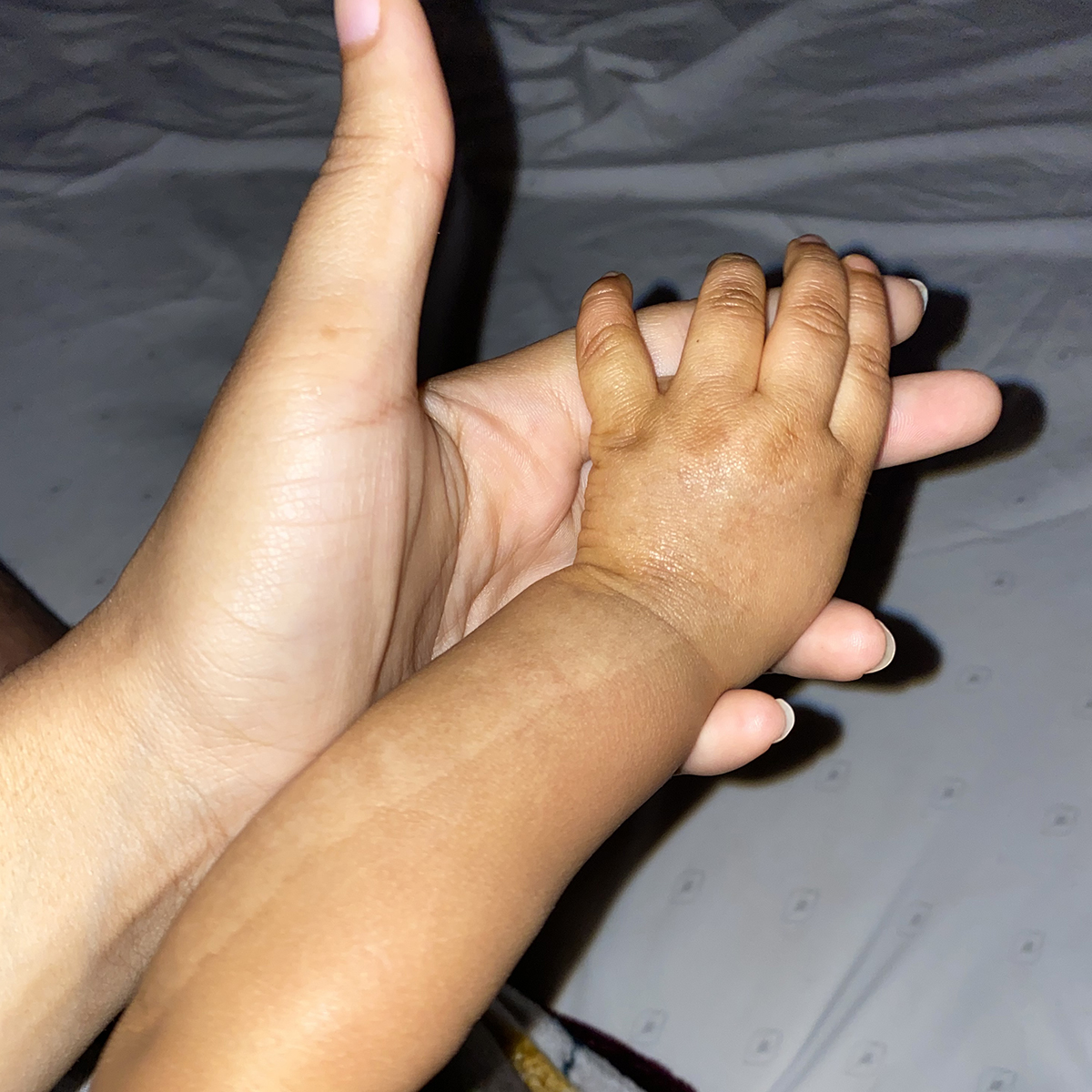 Jazmyne holding her baby's hand.