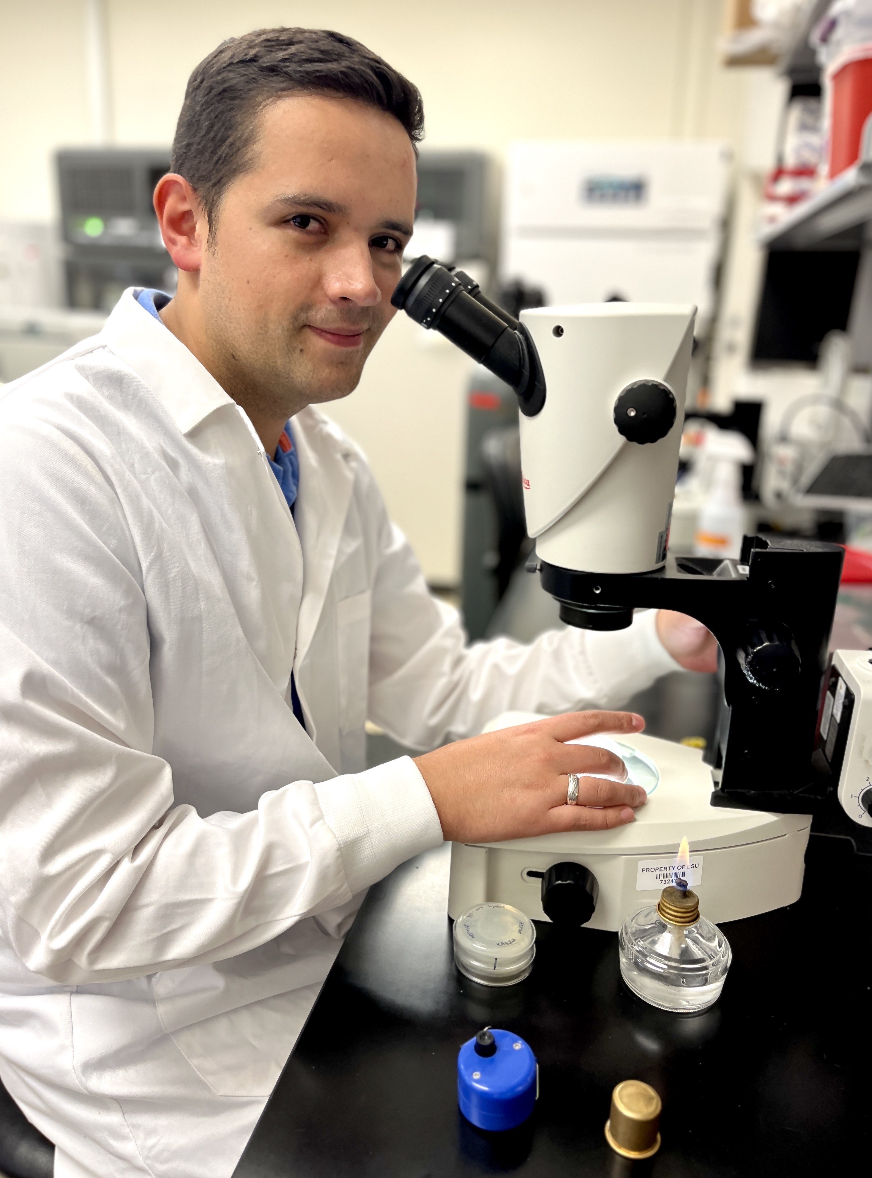 Cristian Perez Student working with a microscope at a lab bench.