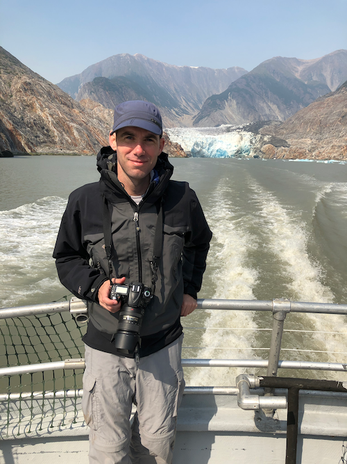Dr. Adam Forte on a boat with his camera, performing fieldwork among glaciers in Tracy Arm Fjord, south of Juneau, Alaska, at a conference on climate-tectonic interactions.