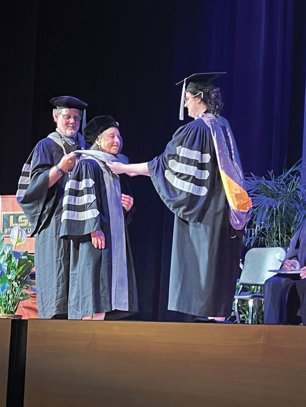 Dr. Justine Bruner being hooded by Drs. Joseph Taboada and Shannon Dehghanpir